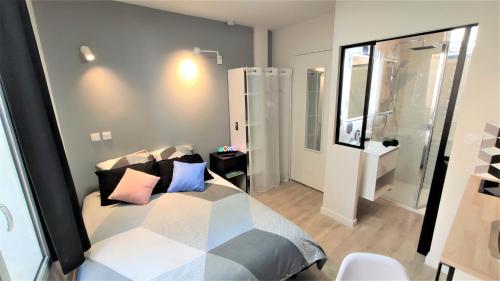 Un dormitorio con una cama con almohadas. en Home&Work 101 - HYPERCENTRE - Parking à proximité, en Niort