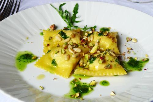 a white plate of food with broccoli and nuts at Albergo Il Giglio in Montalcino