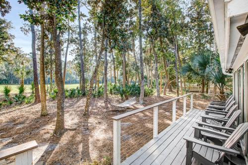 a wooden porch with chairs and trees at Seabrook Island Geataway in Seabrook Island