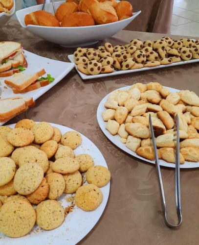 a table with plates of cookies and sandwiches and bread at Biss Inn Hotel in Goiânia