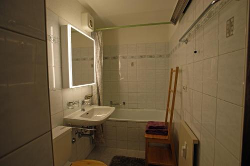 a bathroom with a sink and a tub and a mirror at Haus Euphrasia in Klosters