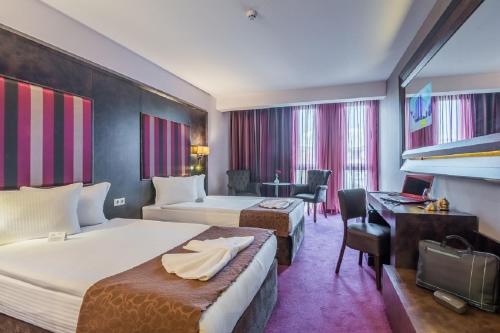 スタラ・ザゴラにあるBest Boutique Hotelのベッド2台とデスクが備わるホテルルームです。