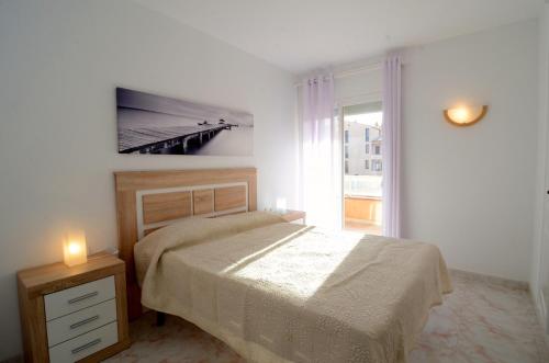 a white bedroom with a bed and a window at Golf Mar II A 1-4 in Pals