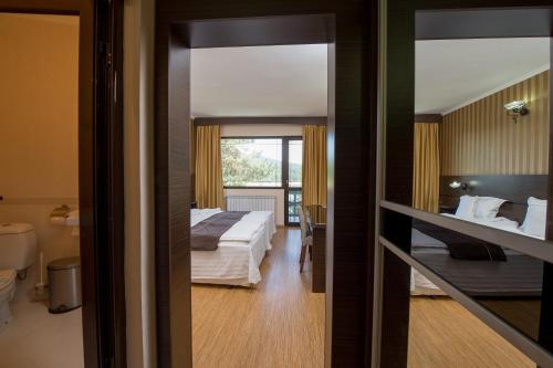 a hotel room with a bed and a bathroom at Family Hotel Hebar in Batak