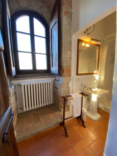 baño con lavabo y ventana en Castello di Mugnana, en Mugnana