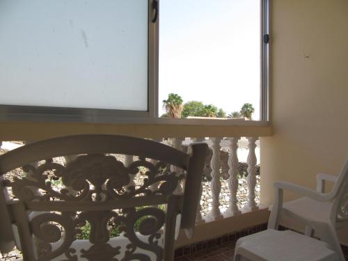 a balcony with a table and a chair and a window at Tarrafal Residence in Tarrafal