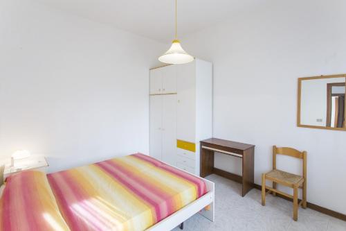 een slaapkamer met een bed, een bureau en een stoel bij Villa Generosa in Lido di Jesolo