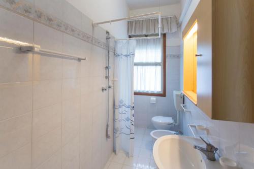 een badkamer met 2 toiletten, een wastafel en een douche bij Villa Generosa in Lido di Jesolo
