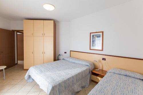 1 dormitorio con 2 camas y armario en Robinia/Pinetine Lido Altanea, en Caorle