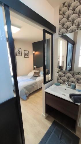 une chambre avec un lit, un lavabo et un miroir dans l'établissement Home&Work 201 - HYPERCENTRE - fibre et parking a proximité, à Niort
