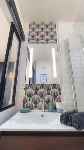 une salle de bain avec un lavabo et un miroir dans l'établissement Home&Work 201 - HYPERCENTRE - fibre et parking a proximité, à Niort