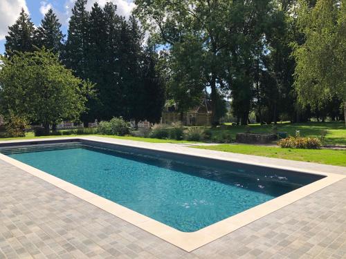 a swimming pool in a yard with trees and grass at Chateau de Vauchelles in Vauchelles-lès-Domart