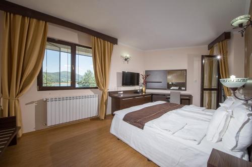 a bedroom with a large bed and a television at Family Hotel Hebar in Batak