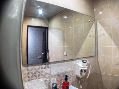 a bathroom with a sink and a large mirror at Apartment Studio in town centr in Kamianets-Podilskyi