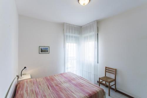 リド・ディ・イエゾロにあるCosta Del Solのベッドルーム1室(ベッド1台、椅子、窓付)