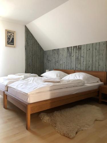 1 dormitorio con 1 cama grande y cabecero de madera en Villa Capri, en Nová Lesná