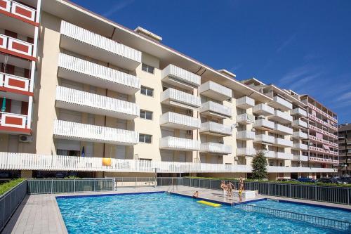 un edificio con piscina di fronte a un edificio di Residence Holiday a Porto Santa Margherita di Caorle