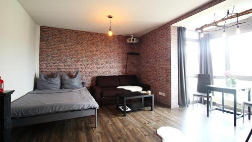 een slaapkamer met een bakstenen muur en een bed en een bank bij home cinema, parking space - Place for 4 in Würzburg