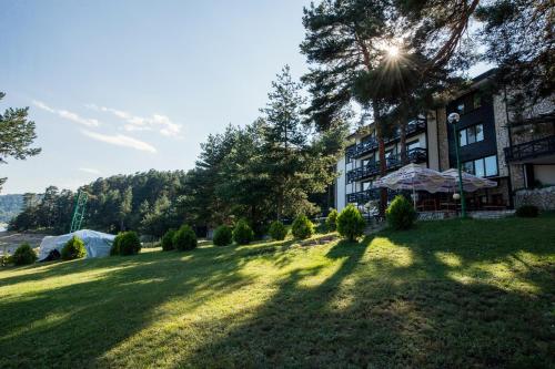 a large grassy yard in front of a building at Family Hotel Hebar in Batak