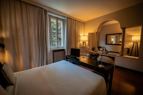 a bedroom with a bed and a desk and a window at Santa Maria Foris in Ravenna