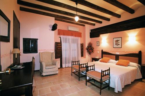 a bedroom with a bed and a table and chairs at Hospederia Meson de la Dolores in Calatayud