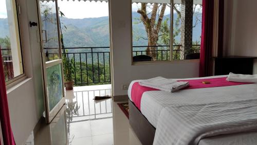 a bedroom with a bed and a balcony with a view at Green Tea View in Munnar