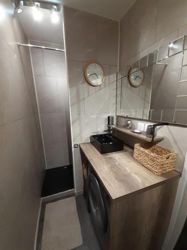 - un lave-linge dans une salle de bains avec 2 réveils sur le mur dans l'établissement Le BELVEDERE 2 - Acces Direct Plage, à Argelès-sur-Mer