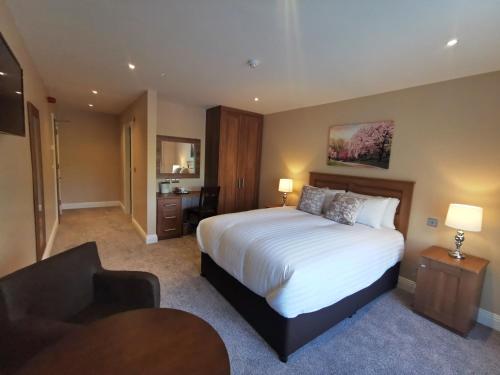 a hotel room with a large bed and a chair at Hillview House in Lusk