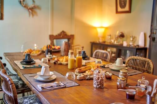 カステにあるBEL AIR MAISON D'HOTES DES LANDESの長い木製テーブル(食べ物、飲み物付)