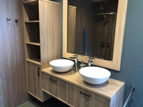ein Badezimmer mit zwei weißen Waschbecken und einem Spiegel in der Unterkunft Slaperij Salud! Studios & appartementen in Scharendijke