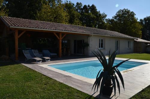 a house with a swimming pool in a yard at Le Refuge des Épicuriens in Eymet
