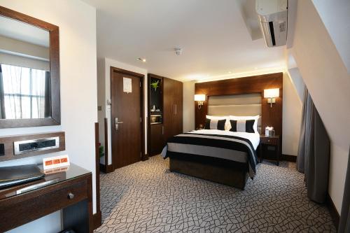 ein Hotelzimmer mit einem Bett und einem Waschbecken in der Unterkunft Paddington Court Executive Rooms in London