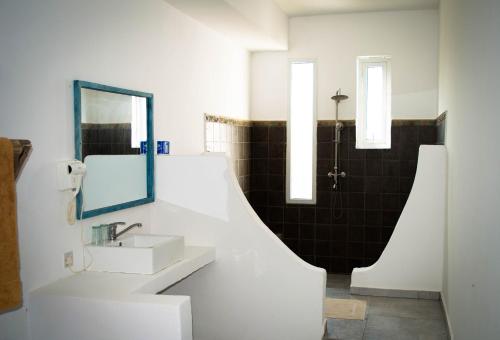 a white bathroom with a sink and a mirror at Pemba Paradise in Makangale