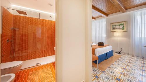 a bathroom with a shower and a toilet and a bedroom at Maison Amalia in Sorrento