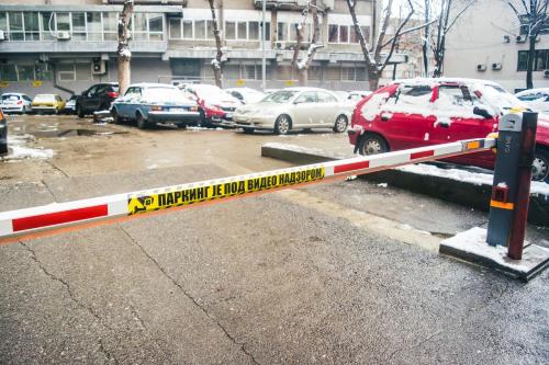 a barrier in a parking lot with cars parked at Aparment Theatre in Niš