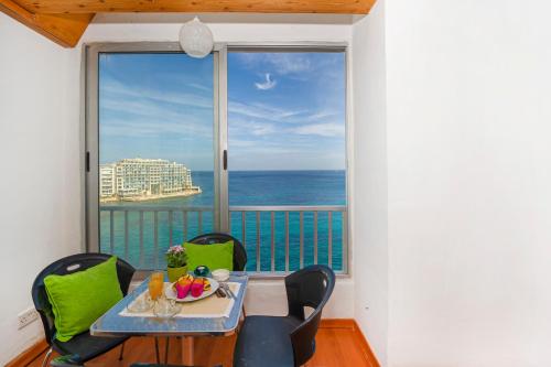 ein Esszimmer mit Blick auf das Meer in der Unterkunft Spinola Bay top floor seafront 3 bedroom Apartment with panoramic sea views - by Getawaysmalta in St Julian's