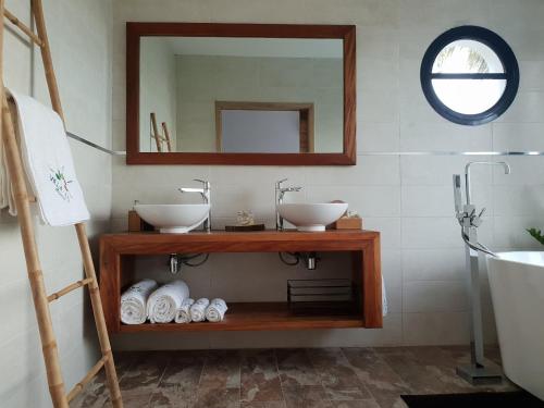 a bathroom with two sinks and a mirror at Villa Ilo Majunga in Mahajanga