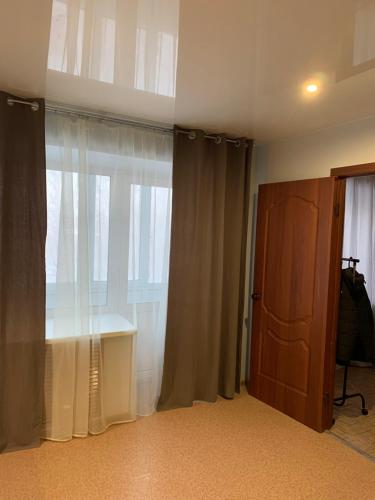 イヴァノヴォにあるДвухкомнатная квартира-студияの窓と木製のドアが備わる部屋