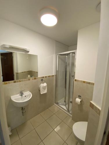 a bathroom with a sink and a shower and a toilet at Wendover Arms Hotel in High Wycombe