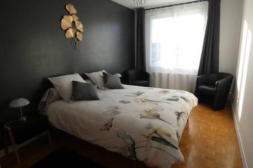 a bedroom with a bed and a window with a bedspread at Les ammonites gîte de charme en Bourgogne in Guillon