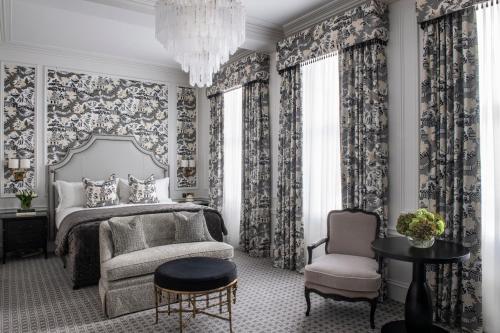 a bedroom with a bed and a chair and a chandelier at The Kensington Hotel in London