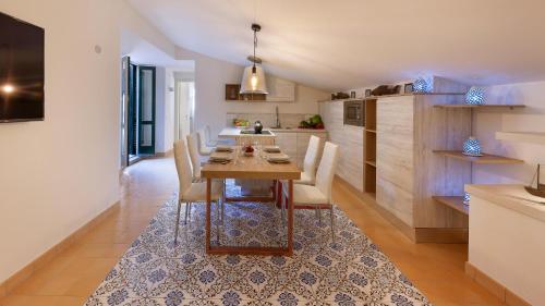 a dining room with a table and chairs in a kitchen at Maison Amalia in Sorrento