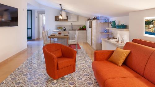 a living room with a couch and a chair and a kitchen at Maison Amalia in Sorrento