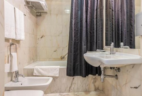 La salle de bains est pourvue de 2 lavabos, d'une baignoire et de toilettes. dans l'établissement Hotel Solar Dos Mascarenhas, à Vila Viçosa