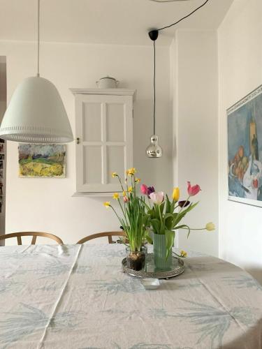 a table with a vase of flowers on it at ApartmentInCopenhagen Apartment 547 in Copenhagen