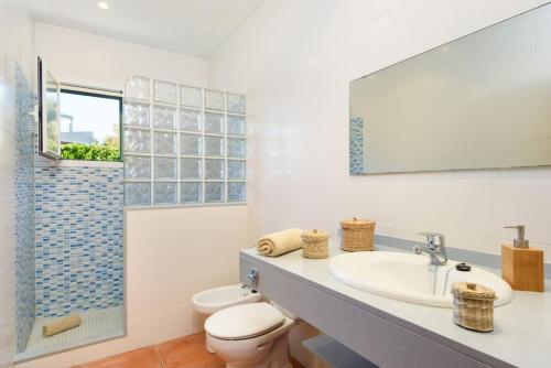 a bathroom with a sink and a toilet at Villa Rose in Sant Lluis