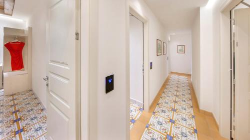 a hallway with a white door and a tile floor at Maison Amalia in Sorrento