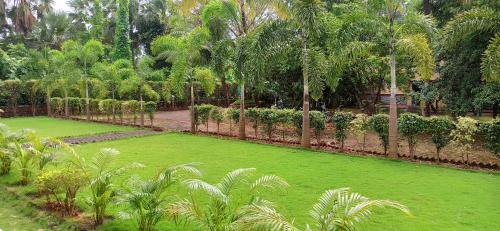 a green lawn with palm trees and a fence at Kamal Homes in Kīhīm