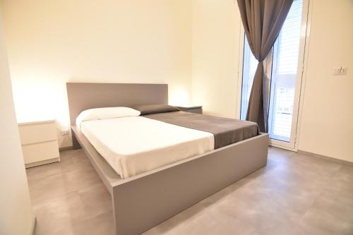 a bed in a bedroom with a large window at Santa Barbara House in Marina di Ragusa