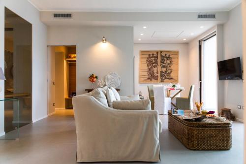 a living room with white chairs and a table at NESOS SUITE by DomuSicily in Mondello
